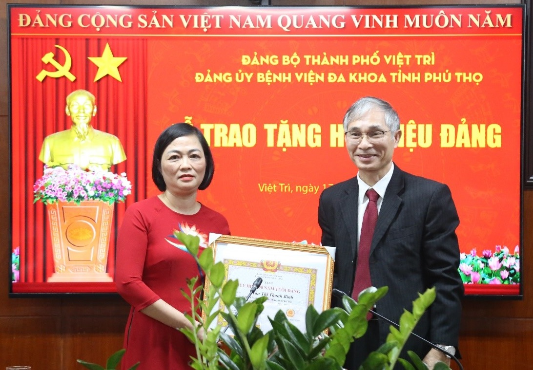 Đồng chí Phạm Văn Mến đã trao Huy hiệu Đảng và Quyết định cho đồng chí Trần Thị Thanh Bình – Đảng viên được nhận Huy hiệu 30 năm tuổi Đảng